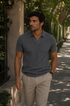 Homem usando Camisa Polo Italiana Ravello Masculina em tricô premium na cor cinza grafite escuro em ambiente externo.