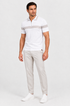 Polo branca com calça bege-clara e tênis branco